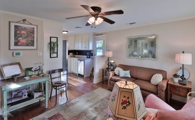 Living room of guest house with wood finished floors, a ceiling fan, and ornamental molding | Image 30