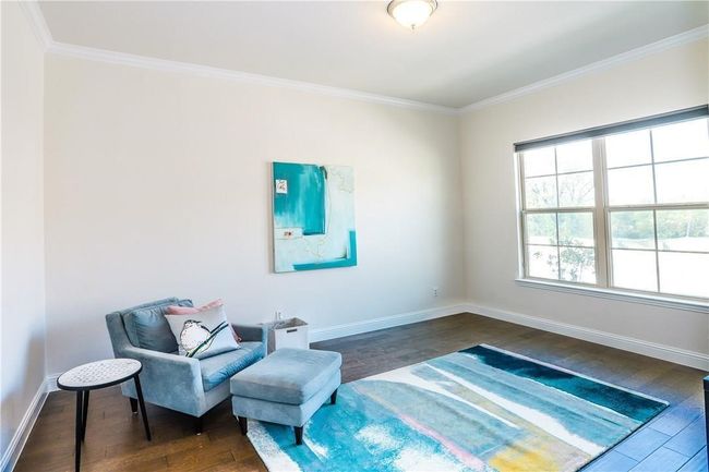 Sitting room with dark wood-type flooring and crown molding | Image 6