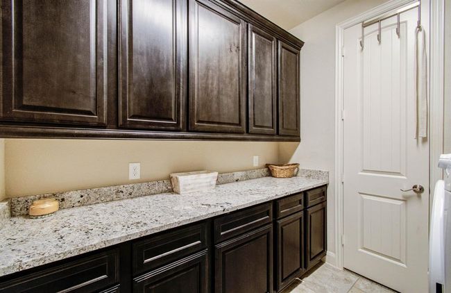 The laundry room includes ample cabinets, drawers, and countertop space. | Image 42
