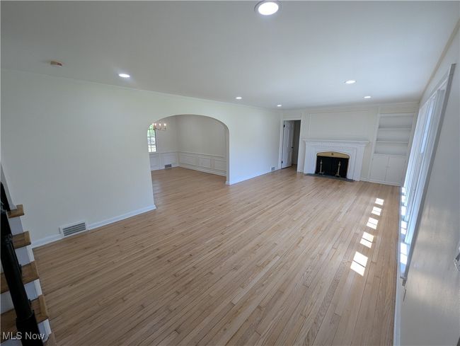 Unfurnished living room featuring recessed lighting, arched walkways, light wood-type flooring, and visible vents | Image 9