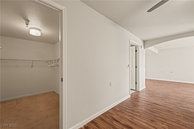Hallway with arched walkways, wood finished floors, and baseboards | Image 18