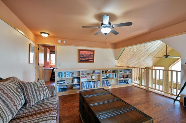 The loft has built-in bookshelves and hardwood floors that match the main floor. | Image 32