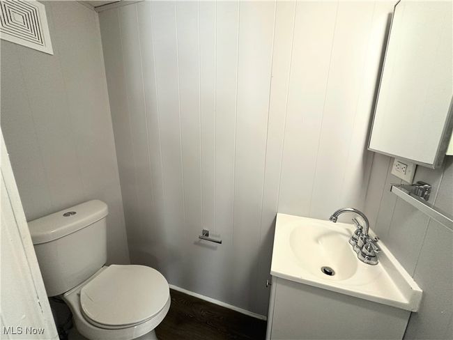 Bathroom with toilet, vanity, wood finished floors, and visible vents | Image 11