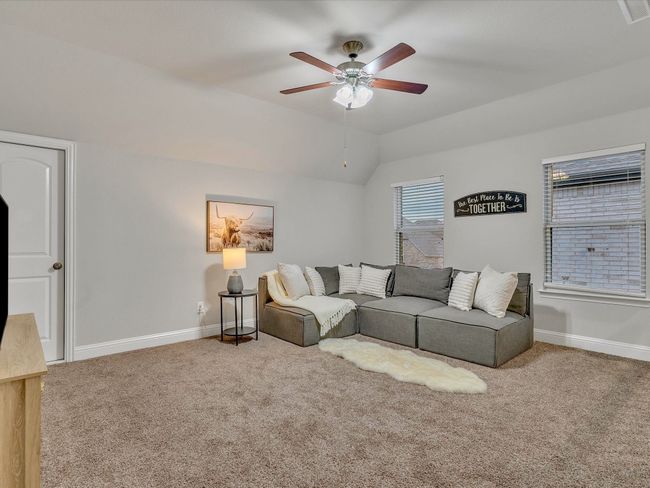 Living area featuring a ceiling fan, carpet, and lofted ceiling | Image 23