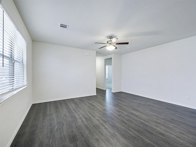 Spare room featuring ceiling fan and dark wood-style flooring | Image 4