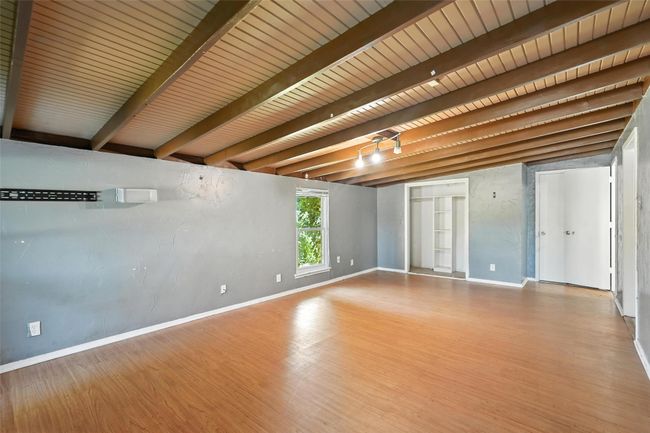 Empty room featuring beamed ceiling and wood finished floors | Image 20