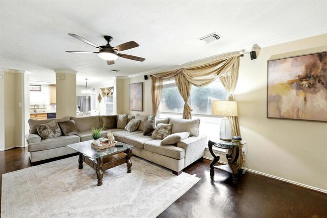 This open-concept family room flows seamlessly into the kitchen and breakfast area, offering ample seating. A perfect space for relaxing or entertaining guests. | Image 10