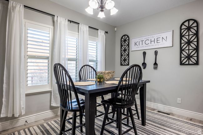 Dining room featuring a healthy amount of sunlight, hardwood / wood-style floors, and a notable chandelier | Image 8