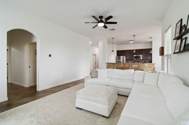 Living room featuring ceiling fan, arched walkways, and baseboards | Image 8