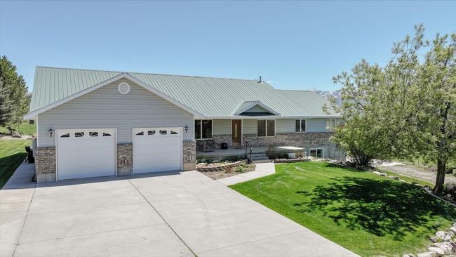 View of front of home featuring driveway, an attached garage, a front yard, and covered porch | Image 5
