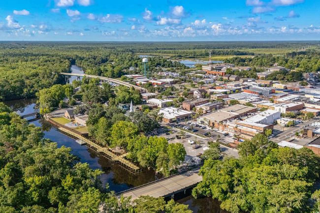 Aerial view of property's location with a nearby body of water and a heavily wooded area | Image 22