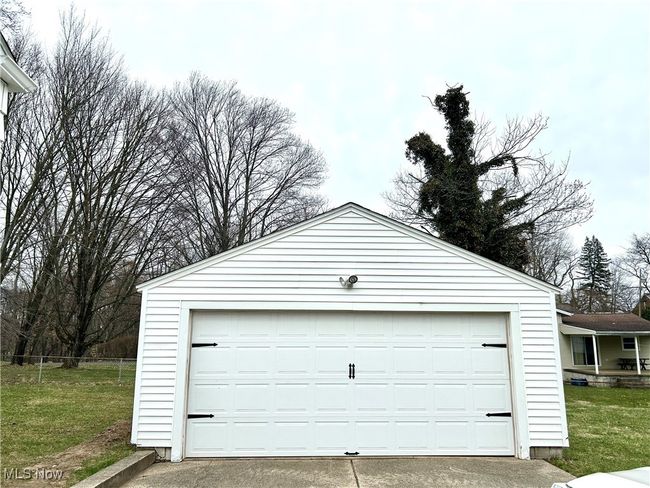 Detached garage with new garage door and plenty of outdoor lighting. | Image 43