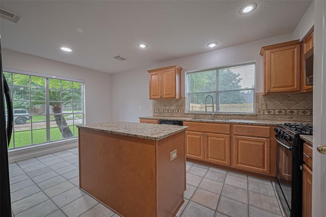 Spacious kitchen with granite countertops, breakfast area overlooking the large front and side yard, and refrigerator included! | Image 11