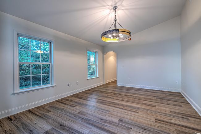 Spare room with a chandelier, arched walkways, and dark wood-style flooring | Image 32