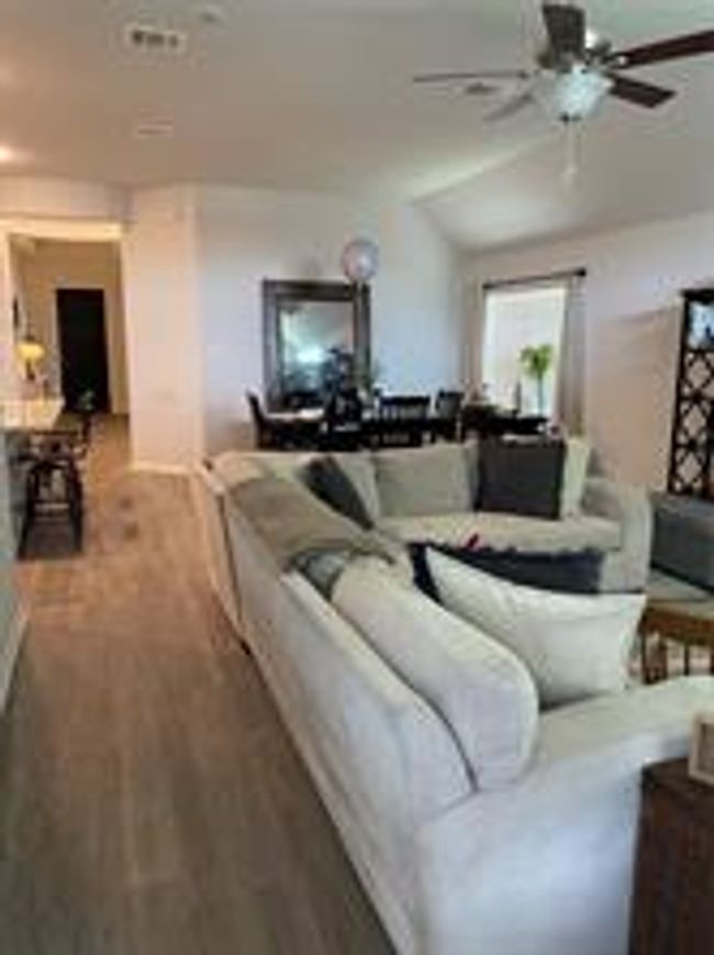 Living area with wood finished floors and ceiling fan | Image 4
