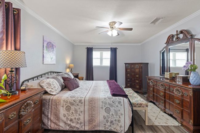 Bedroom with wood finished floors, crown molding, and ceiling fan | Image 10