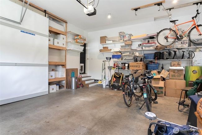 Impressively large two-car garage with a soaring ceiling and custom built-in shelving behind sliding barn doors. | Image 35