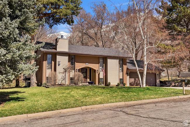 View of front of home with a chimney, a front yard, an attached garage, and concrete driveway | Image 6