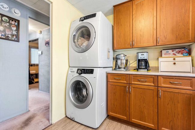 Laundry area featuring stacked washing maching and dryer and laundry area | Image 17