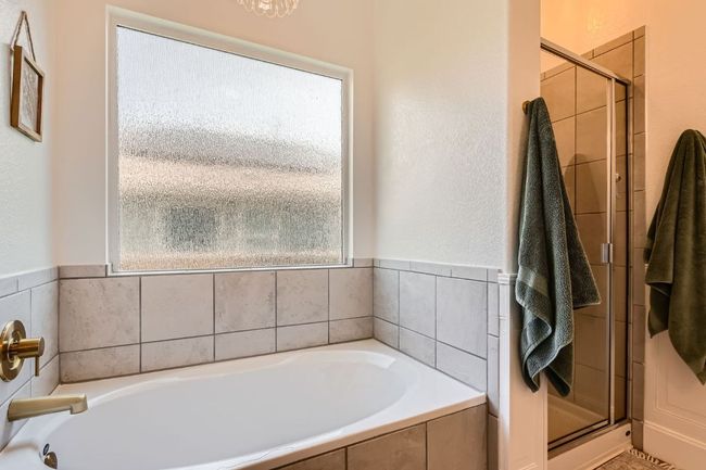 Bathroom with a shower stall and a bath | Image 17