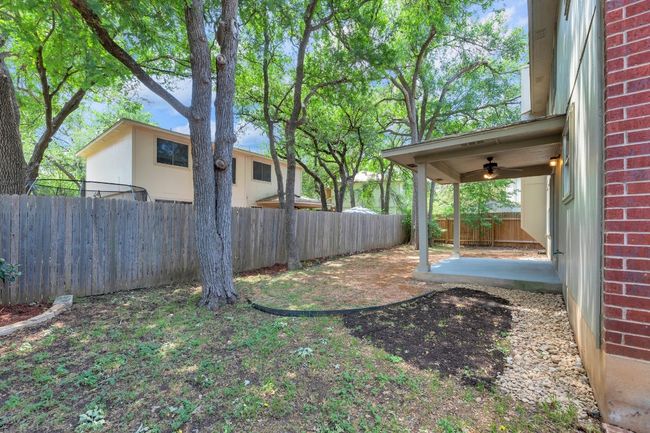 View of yard featuring a fenced backyard, a patio area, and a ceiling fan | Image 32