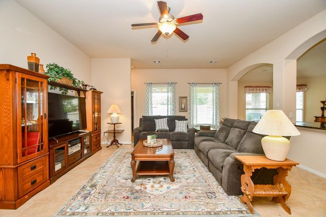 Natural light fills the space through multiple windows with elegant curtains, complemented by warm lighting from stylish lamps. | Image 8
