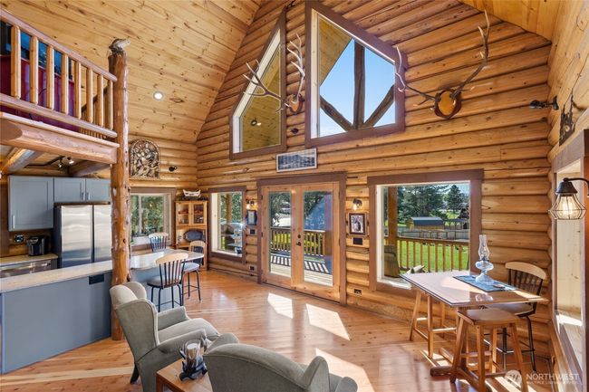 Vaulted ceilings and a wall of windows allowing natural light to fill the living space. | Image 10