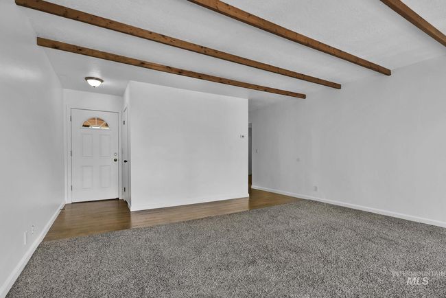 Carpeted spare room featuring beam ceiling and baseboards | Image 7