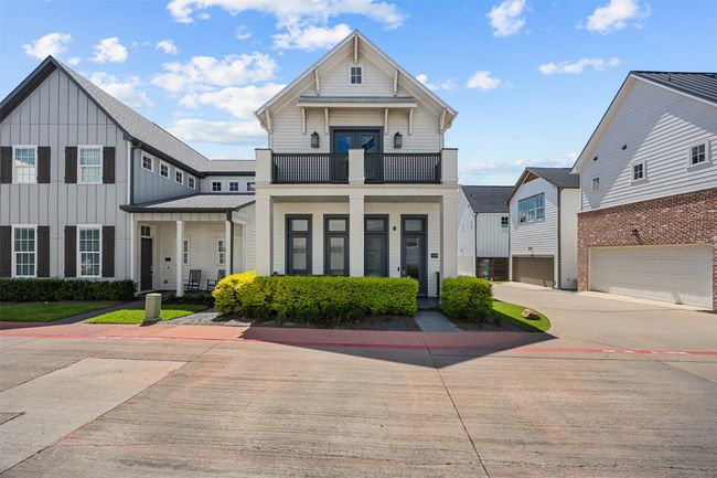 View of front of house featuring a balcony, board and batten siding, a garage, and driveway | Image 35