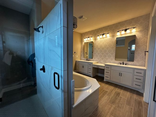 Bathroom with a shower stall, two vanities, a garden tub, and wood tiled floors | Image 13