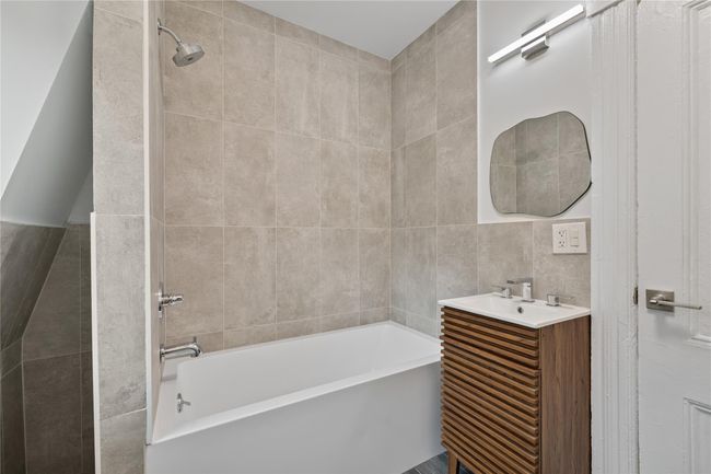 Full bath with tile walls, bathtub / shower combination, and vanity | Image 20