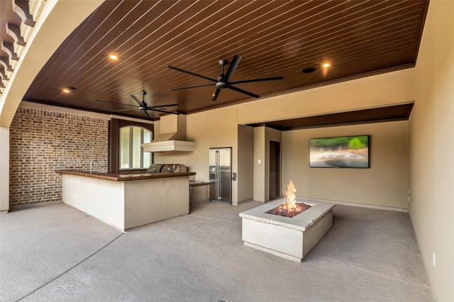 Surrounding the pool is a beautifully designed outdoor living space complete with a fully equipped outdoor kitchen and a cozy fire pit—perfect for evening gatherings and al fresco dining. Wired for surround sound with speakers included. | Image 36