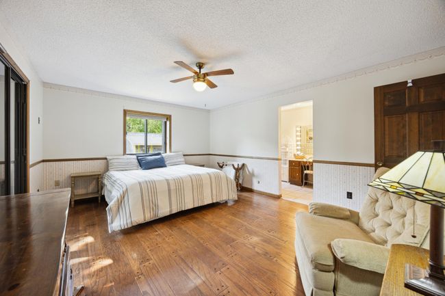 4 bedrooms on the upper level. This is the primary bedroom with bathroom and walk-in closet. On the left there is a patio door to a balcony overlooking the lake. | Image 13