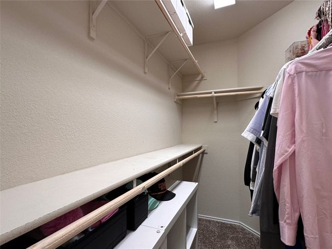 Spacious closet featuring dark colored carpet | Image 35