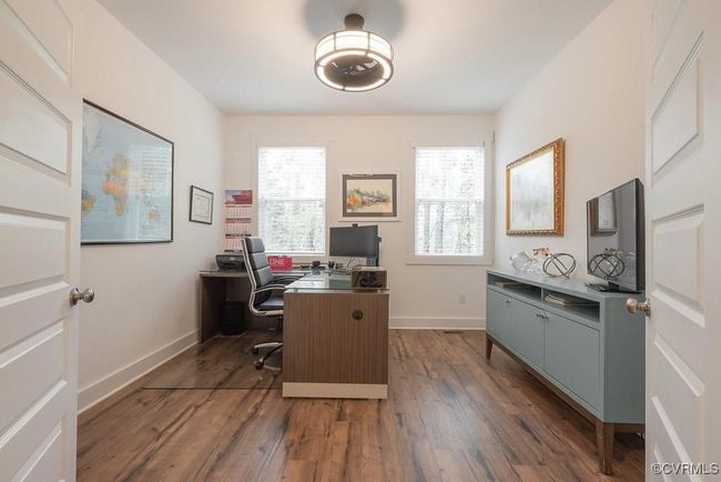 Office area with healthy amount of natural light and dark wood-type flooring | Image 12