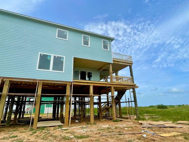 This under-construction image highlights the screened-in patio area and thoughtful VE-zone structural engineering with breakaway walls, storm-rated windows, and multi-level decking. A rare chance to own new construction built for generations, not just seasons. | Image 17