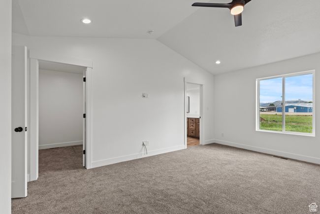 Unfurnished bedroom featuring carpet flooring, lofted ceiling, baseboards, recessed lighting, and ceiling fan | Image 10