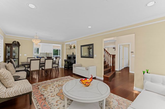 Living area with wood finished floors, stairway, crown molding, and recessed lighting | Image 4
