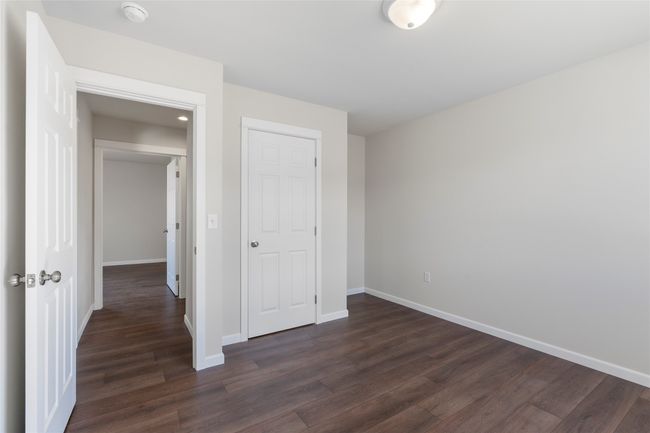 Unfurnished bedroom featuring baseboards and dark wood-style flooring | Image 55