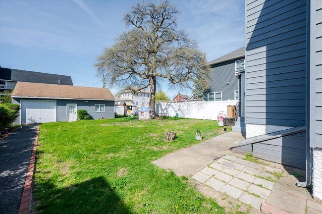 View of yard featuring fence, an attached garage, and driveway | Image 19