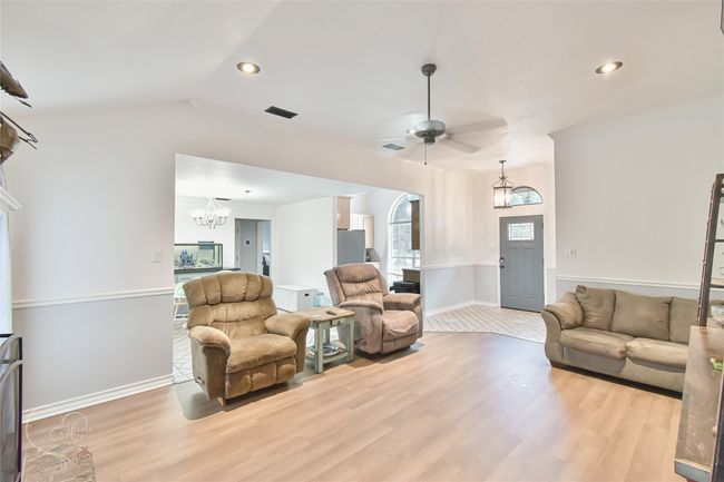 Living room with a chandelier, light wood-type flooring, a ceiling fan, vaulted ceiling, and recessed lighting | Image 30