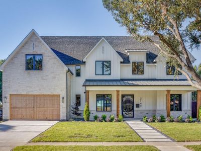 Modern farmhouse style home featuring covered porch, a garage, and a front lawn | Image 1