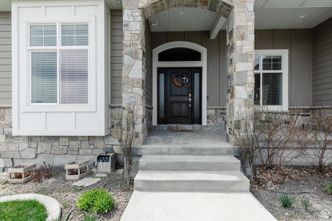View of exterior entry with stone siding and board and batten siding | Image 24