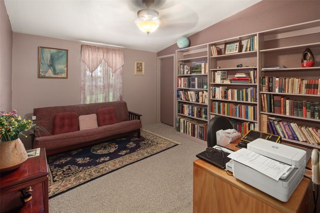 Bedroom currently used as a home office with carpet floors and ceiling fan | Image 26