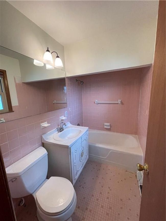 Full bathroom featuring toilet, tile walls, shower / washtub combination, and vanity | Image 18
