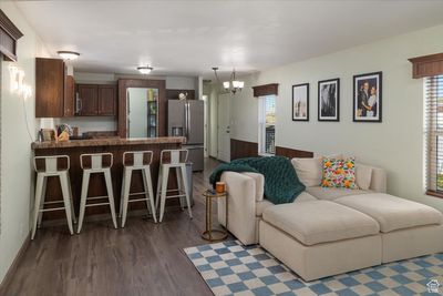 Living room featuring dark wood-type flooring and an inviting chandelier | Image 2