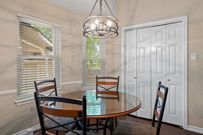 Dining area with a chandelier, dark wood finished floors, and baseboards | Image 19