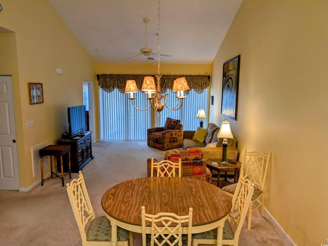 Dining room featuring baseboards, visible vents, carpet, and ceiling fan with notable chandelier | Image 5