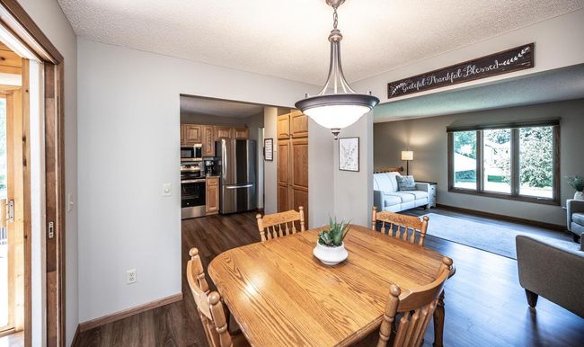 Dining room has chandelier with dimmer control & is open to kitchen & living room. | Image 11