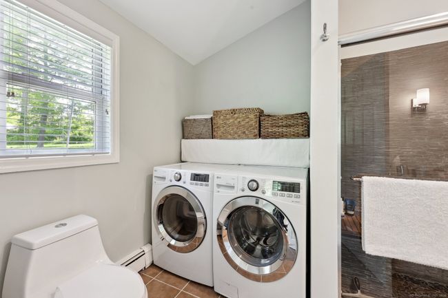 Main level full bath has laundry area tucked away in the corner.. | Image 16